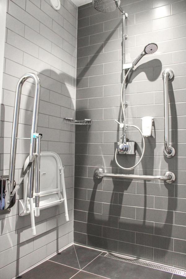فندق هوليداي إن إكسبريس لندن هيثرو تي 4 المظهر الخارجي الصورة A shower stall with grab bars and a shower chair.